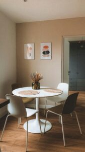 Stylish minimalist dining room with round table and modern decor.